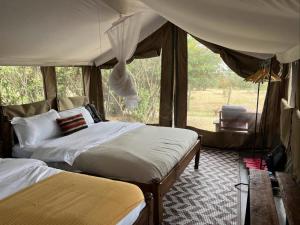a bedroom with two beds in a tent at Kambu Mara Camp in Sekenani +25 photos