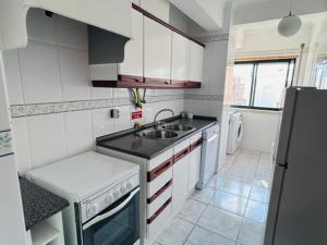a small kitchen with a sink and a refrigerator at SwordFish Beach Escape Apartment in Atouguia da Baleia +8 photos