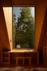 a window in a wooden room with a bench in front at The Down-to-Earth in Rawdon