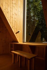 a bench sitting under a window in a cabin at The Down-to-Earth in Rawdon