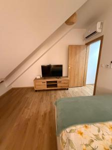 a bedroom with a tv and a bed in a room at W sercu Rynku in Pasym
