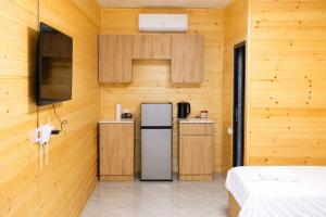 a kitchen with a refrigerator in a wooden wall at SkyGate Hotel in Pʼarakʼar