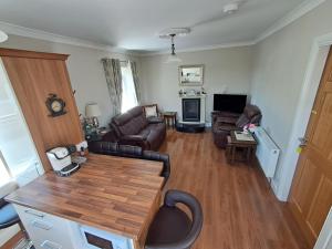 a living room with a couch and a table at Warm Spacious Three Bed Chalet in Galway