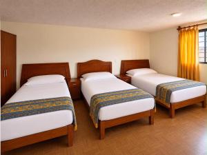 a room with three beds in a room at Hotel Bartolomé in Oaxaca City