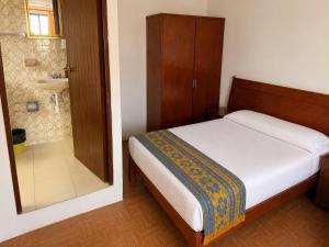 a small bedroom with a bed and a shower at Hotel Bartolomé in Oaxaca City