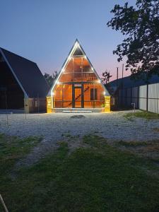 a large wooden barn with a large window at Kungut A-Frame Deluxe in Sheki