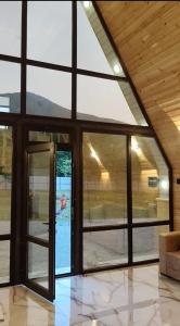 a room with large glass windows and a view of a pool at Kungut A-Frame Deluxe in Sheki