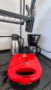 a red plate sitting on the floor next to a stove at Pousada Alforria Lavras Novas centro in Lavras Novas