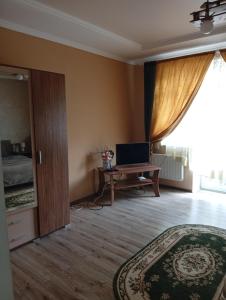a room with a bed and a desk with a laptop at Gray in Ternopil