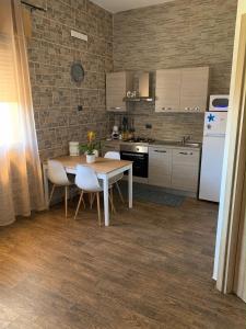 a kitchen with a wooden table and white appliances at Ribera villa alloggio 1 in Ribera