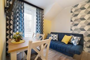 a living room with a blue couch and a table at Bocian Apartamenty in Krynica Zdrój