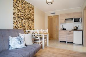 a living room with a couch and a table and a kitchen at Bocian Apartamenty in Krynica Zdrój +50 photos