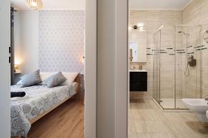 a bedroom with a bed and a bathroom with a shower at Bocian Apartamenty in Krynica Zdrój