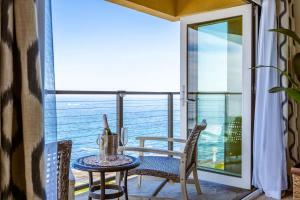 a table and chairs on a balcony with a view of the ocean at Sur La Mer, beachfront, tidal pools in San Diego