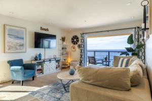 a living room with a couch and a view of the ocean at Sur La Mer, beachfront, tidal pools in San Diego