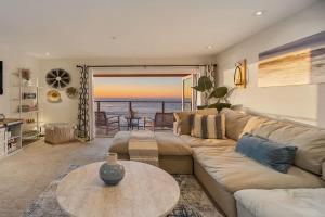 a living room with a couch and a table at Sur La Mer, beachfront, tidal pools in San Diego