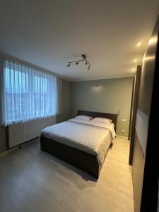 a bedroom with a large bed and a window at Tomorowland Woning in Boom in Boom