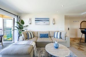 a living room with a couch and a table at Sur La Mer, beachfront, tidal pools in San Diego