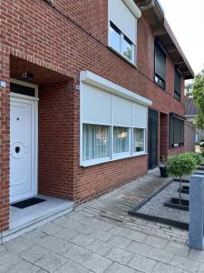 a brick building with a white door and windows at Tomorowland Woning in Boom in Boom