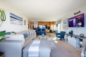 a living room with a couch and a table at Sur La Mer, beachfront, tidal pools in San Diego +29 photos