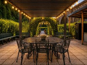 a table and chairs on a patio with lights at B&B Jasmine Park Ormea in Ormea