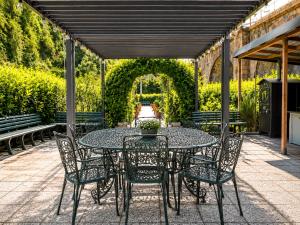 a patio with a table and chairs and an arbor at B&B Jasmine Park Ormea in Ormea