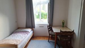 a bedroom with a bed and a desk and a window at Löwenzahn in Scheibbs