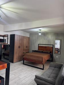 sypialnia z łóżkiem i kanapą w obiekcie Loft centrito w mieście Saltillo