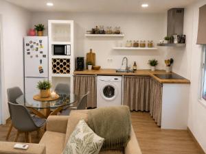 a kitchen with a table and a washing machine at La casa del papica in Níjar