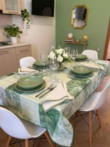 a dining room table with green plates and napkins at Maison Veneto Vesuvius Rooftop in Torre Annunziata
