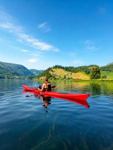 a man in a red kayak on a lake at Birdbox Storehesten in Kvame