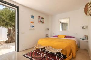 a bedroom with a bed and two chairs at Sunset Sea View Villa with Private Pool in Sant Josep de sa Talaia