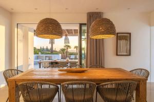 a dining room with a wooden table and chairs at Sunset Sea View Villa with Private Pool in Sant Josep de sa Talaia