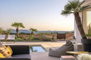 a living room with a pool and palm trees at Sunset Sea View Villa with Private Pool in Sant Josep de sa Talaia +10 photos