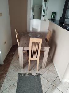 Ein Holztisch und Stühle in einer Küche mit einem Spiegel in der Unterkunft Salvatori in Garić + 7 Fotos