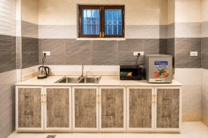 a kitchen with a sink and a microwave at Cozy Quarters in Zanzibar City