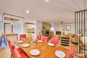a dining table with red chairs and a living room at Le Rustique Moderne Detente - Lake Access in Pohénégamook