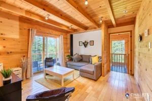 a living room with a couch and a table at Le Rustique Moderne Detente - Lake Access in Pohénégamook