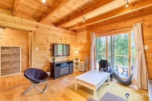 a living room in a log cabin at Le Rustique Moderne Detente - Lake Access in Pohénégamook