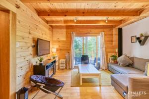 a living room with a couch and a table at Le Rustique Moderne Detente - Lake Access in Pohénégamook