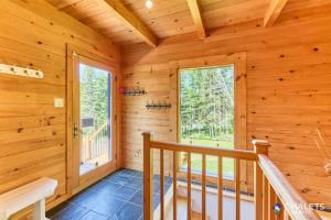 a staircase in a log cabin with a window at Le Rustique Moderne Detente - Lake Access in Pohénégamook +30 photos