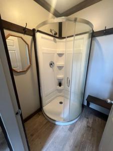 a transparent shower in a room with a wooden floor at Noah's Ark Campground in Malakwa +90 photos