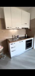a kitchen with white cabinets and a sink at Maison Sofia Mare in Silvi Marina