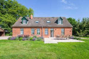 a red brick house with a picnic table in front of it at Kreuzkate-Ostholstein in Manhagen