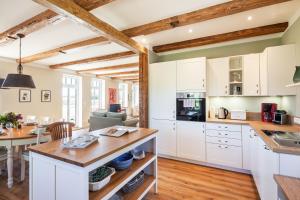 a kitchen and dining room with white cabinets and a table at Kreuzkate-Ostholstein in Manhagen