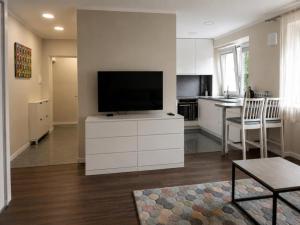 a living room with a television on a white cabinet at Town Square Apartment in Panevėžys