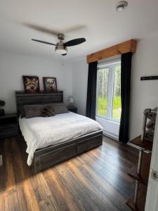 a bedroom with a bed and a large window at Le Béluga in Saint-Calixte