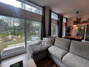a living room with a couch and a large window at Le Béluga in Saint-Calixte +5 photos