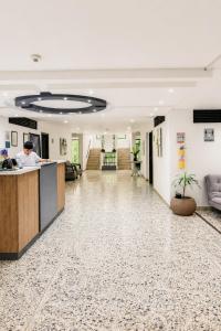 an office lobby with a man at a counter at Hotel Ofix - Laureles in Medellín