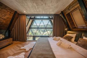 a bedroom with a large bed with a large window at The Frame Croatia in Ravna Gora +48 photos